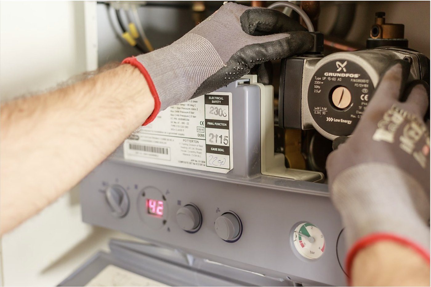 Engineer servicing a gas boiler control panel