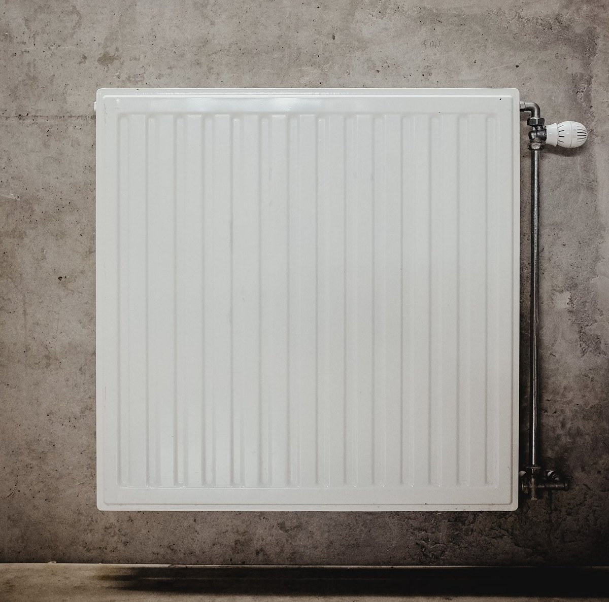 Newly fitted white panel radiator with thermostatic valve